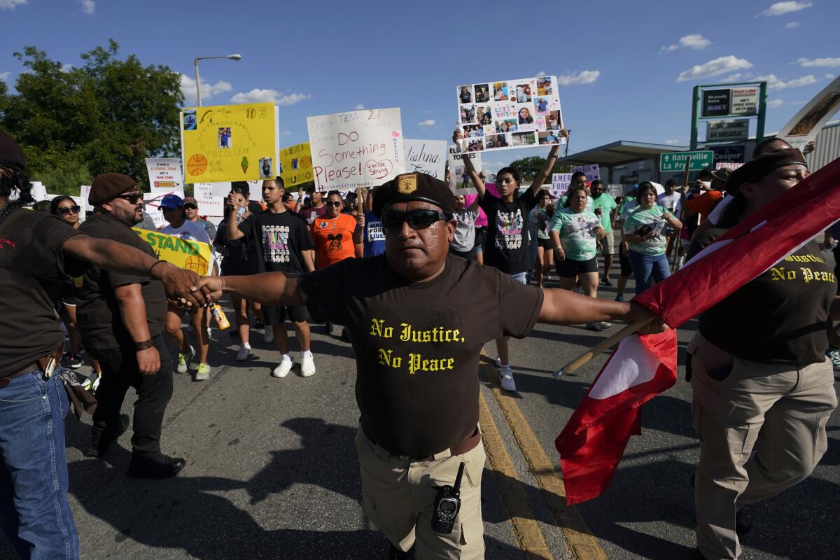 Escorted by the Texas Brown Berets, family and friends of those killed and injured in the school shootings at Robb Elementary take part in a protest march and rally, Sunday, July 10, 2022, in Uvalde, Texas. Families and residents are seeking answers and changes after the tragedy. (AP Photo/Eric Gay)