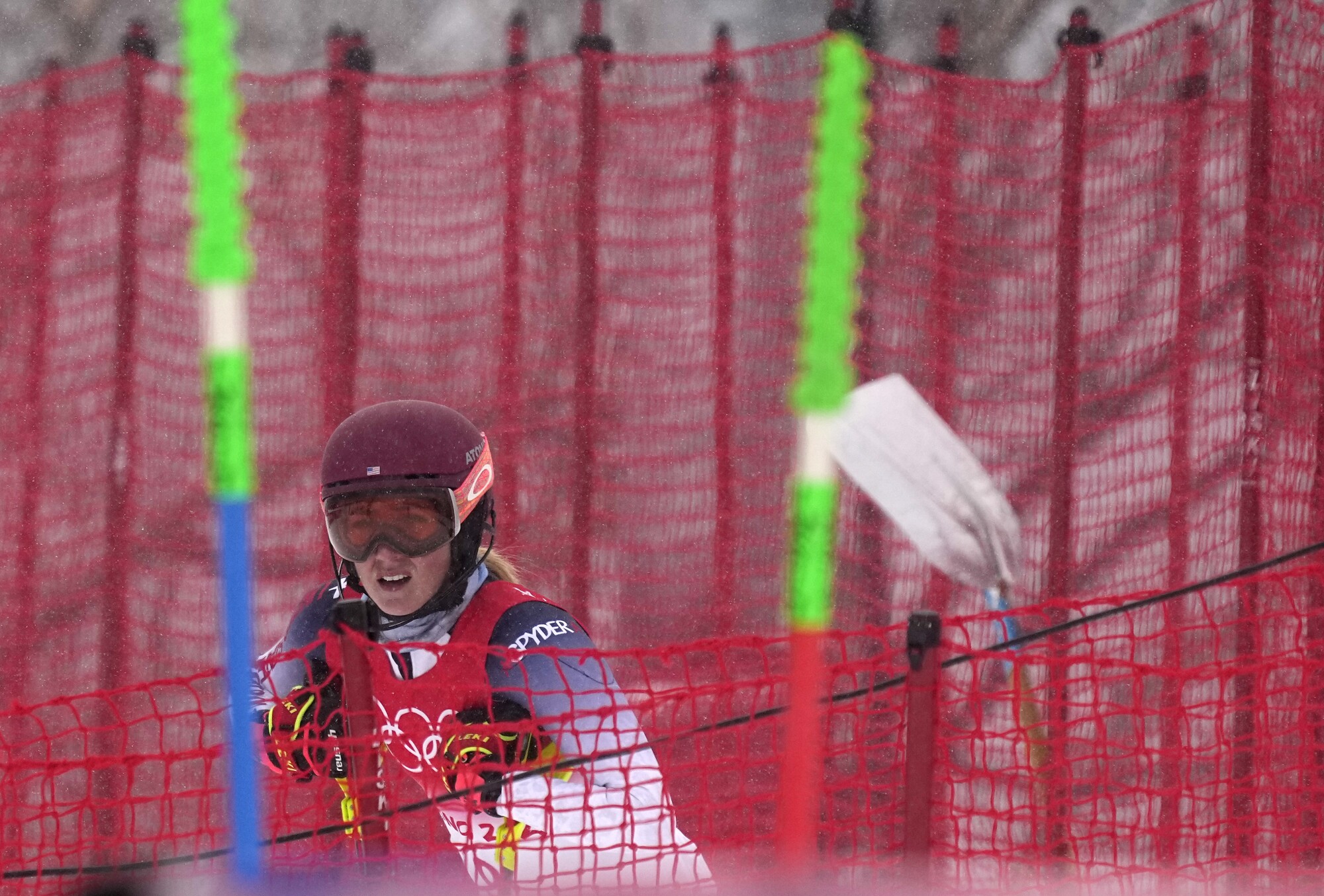 Mikaela Shiffrin fica na lateral do percurso depois de cair durante o slalom combinado feminino.