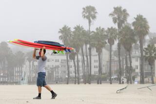 SANTA MONICA, CA - JULY 06: Peter Gratzinger of Pacific Palisades works his way to the water at Santa Monica State Beach which opened to the public at 5 a.m. Monday, July 6, 2020 after being closed for the three-day Fourth of July weekend. (Myung J. Chun / Los Angeles Times)