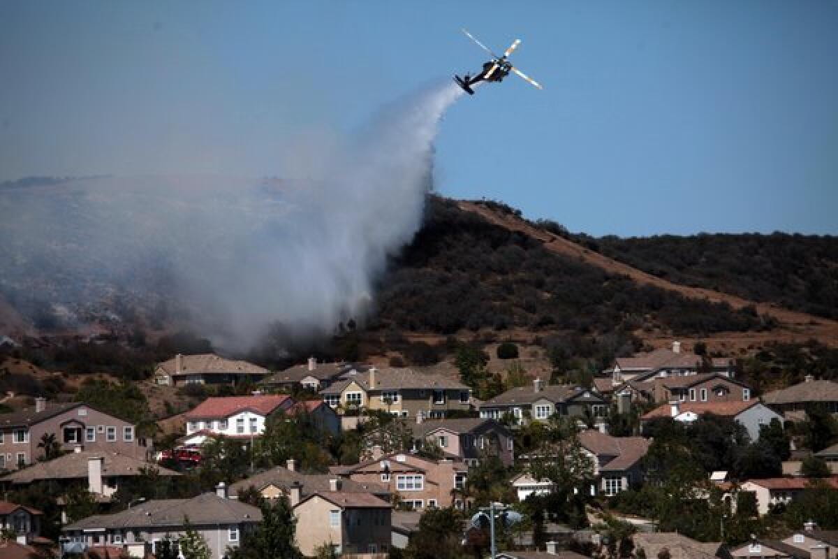 A helicopter douses a fire near Camarillo Springs that was fueled by Santa Ana winds and warm temperatures earlier this yeaar.