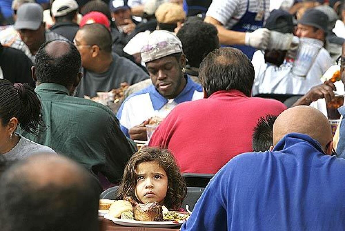 Samantha Ortiz, 3, sits down for a Thanksgiving meal of turkey and all the trimmings at the mission.