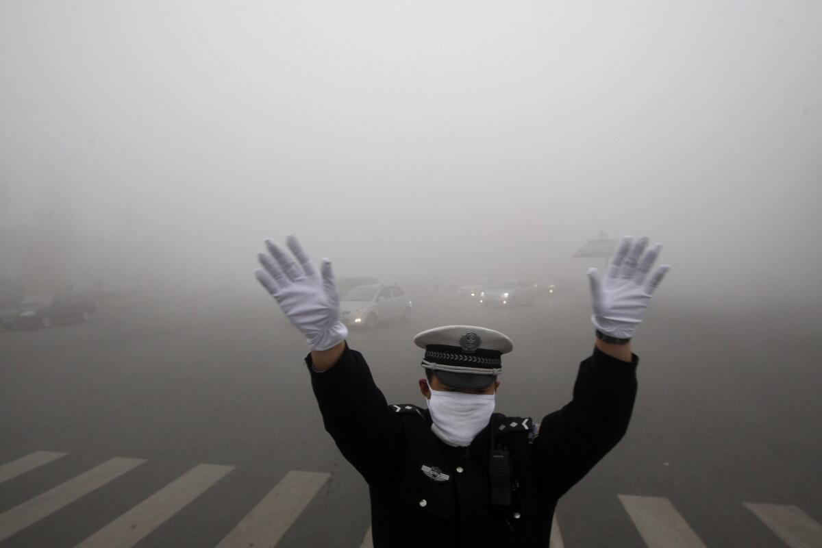 A policeman works on a street in heavy smog in Harbin, in northeast China, on Oct. 21, 2013.