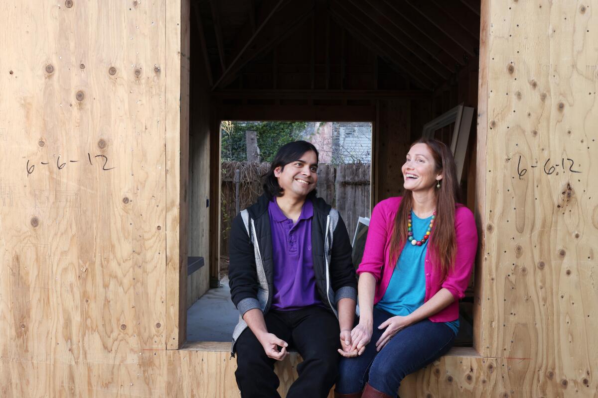 David Guevara Rosillo and Katherine Guevara hold hands in their under-construction building. 