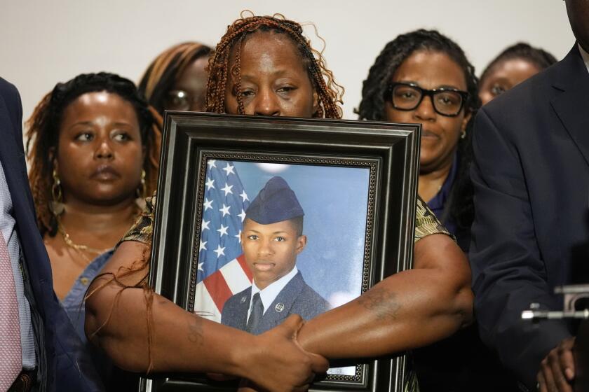 FILE - Chantemekki Fortson, mother of Roger Fortson, a U.S. Air Force senior airman, holds a photo of her son during a news conference with attorney Ben Crump, Thursday, May 9, 2024, in Fort Walton Beach, Fla. A Florida sheriff fired a deputy who fatally shot a Black airman who was standing in his doorway while holding a handgun pointed to the ground. (AP Photo/Gerald Herbert, file)