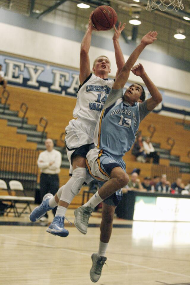 CV's Cole Currie, left, makes a layup while Quartz Hill's Willie Perkins defends Currie during a game at Crescenta Valley High School on Wednesday, December 5, 2012.