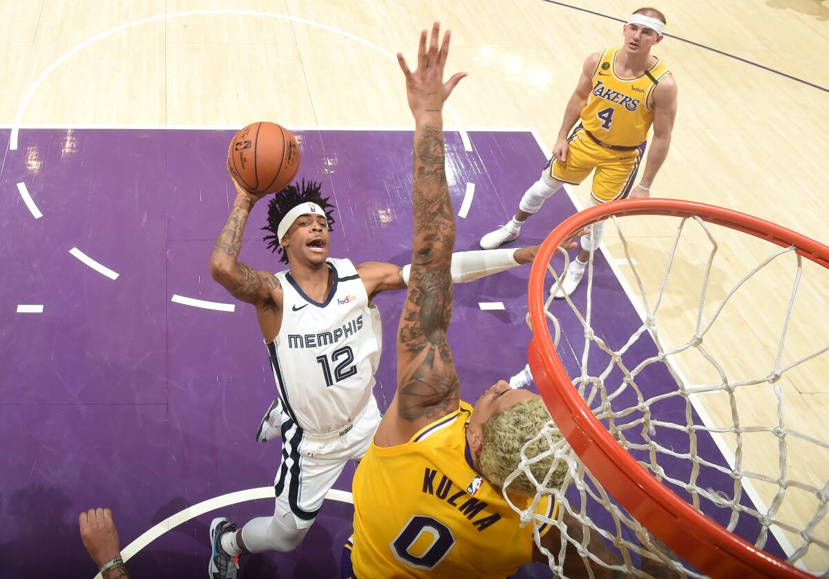 Lakers forward Kyle Kuzma tries to block the shot of Memphis Grizzlies rookie Ja Morant on Feb. 21 at Staples Center.