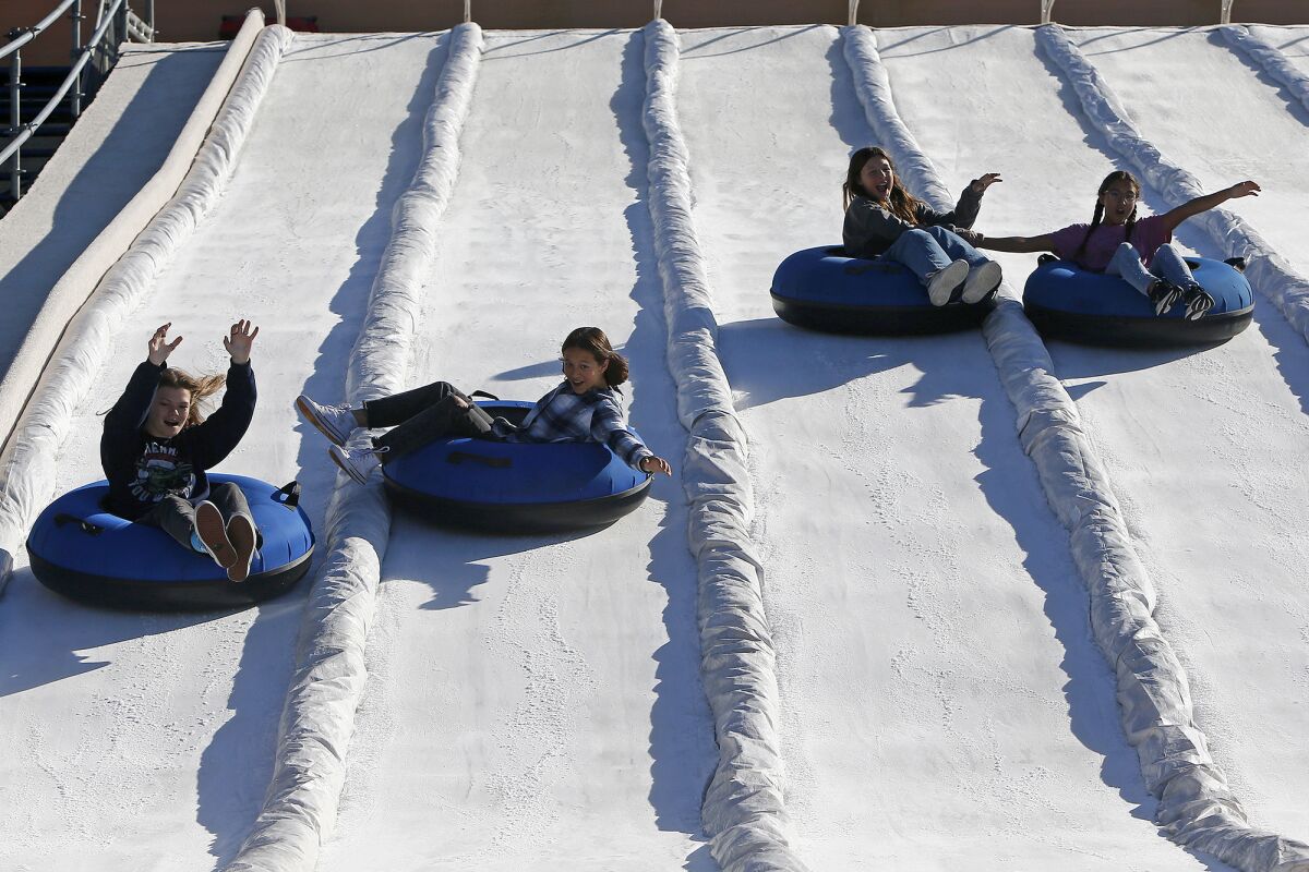  Haylee Hanks, Lacy Duckwitz, Ava Williams and Lily Duckwitz ride down a snow slide at a sneak preview of Winter Fest O.C.