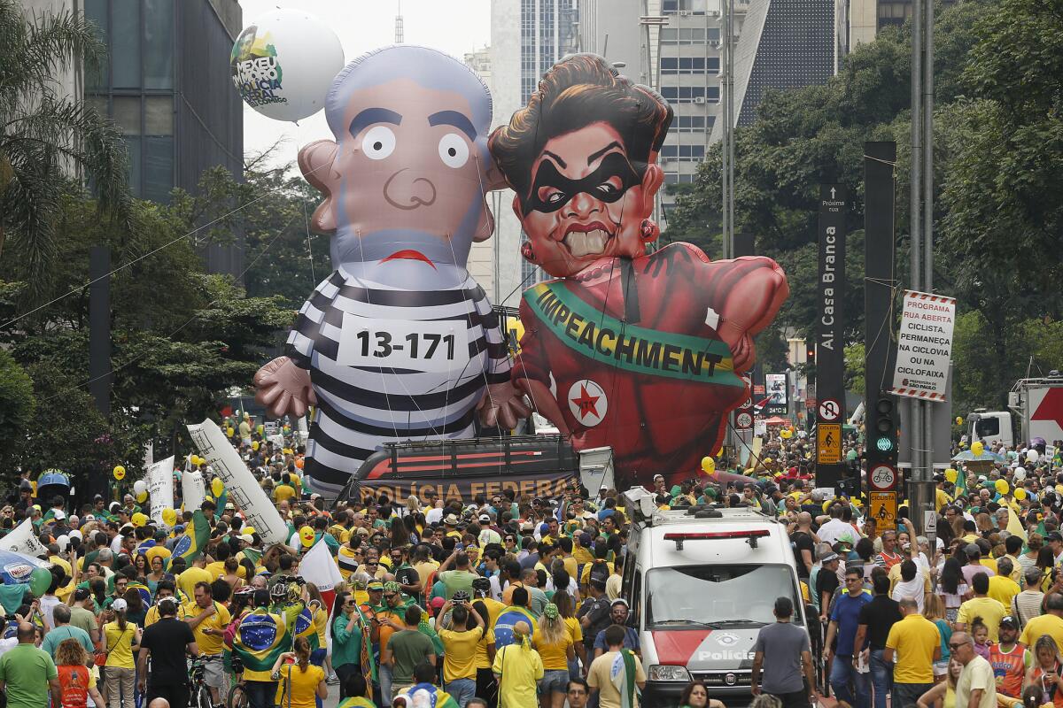 Brazilian demonstrators parade inflatable dolls depicting former President Luiz Inacio Lula da Silva as an inmate and current President Dilma Rousseff as a thief in Sao Paulo on Sunday.