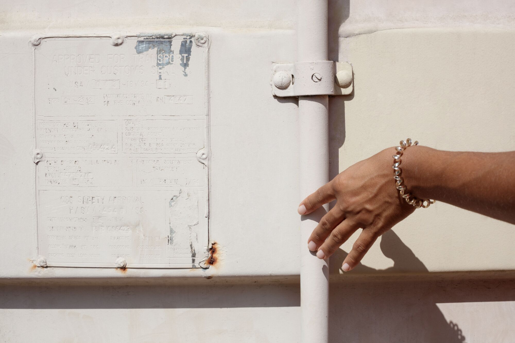 A closeup of Lacey Lennon’s hand touching a storage crate door.