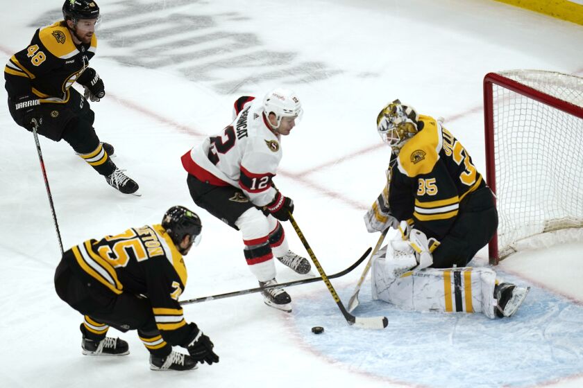 Boston Bruins goaltender Linus Ullmark (35) makes a stick save on a shot by Ottawa Senators right wing Alex DeBrincat (12) during the second period of an NHL hockey game, Tuesday, March 21, 2023, in Boston. (AP Photo/Charles Krupa)