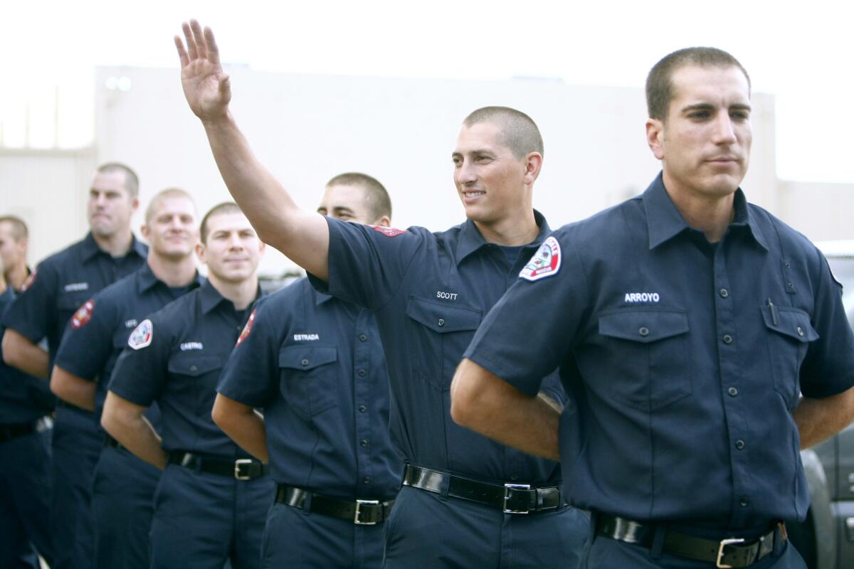 New Burbank Fire Dept. Allen Scott waves to an acquaintance just before the start of the Class of 2016 Burbank and Glendale Fire Departments Firefighter Recruit Academy graduation ceremony, at the Burbank Fire Dept. Training Center in Burbank, on Friday, Dec. 16, 2016. Glendale F.D. had 13 graduates and Burbank had 8 graduates.