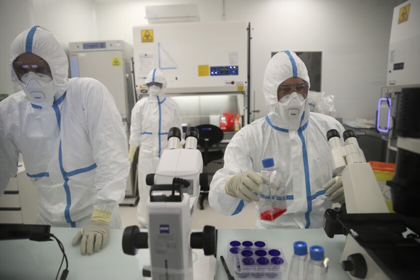 Laboratory technicians work at the Valneva headquarters in Saint-Herblain, western France, Wednesday, Feb.3, 2021. British authorities have authorized a coronavirus vaccine for adults made by the French drugmaker Valneva, despite a decision by the government last year that canceled an order for at least 100 million doses. In a statement on Thursday, April 14, 2022 Britain’s medicines regulator said it had given the green light to the Valneva vaccine, which is made using the decades-old technology used to manufacture shots for flu and polio. (AP Photo/David Vincent)