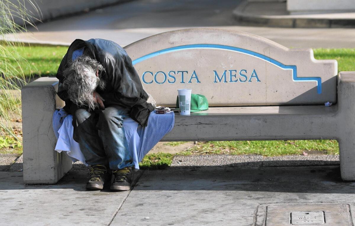 A homeless man sleeps on a bench near Wilson and Harbor blvd.