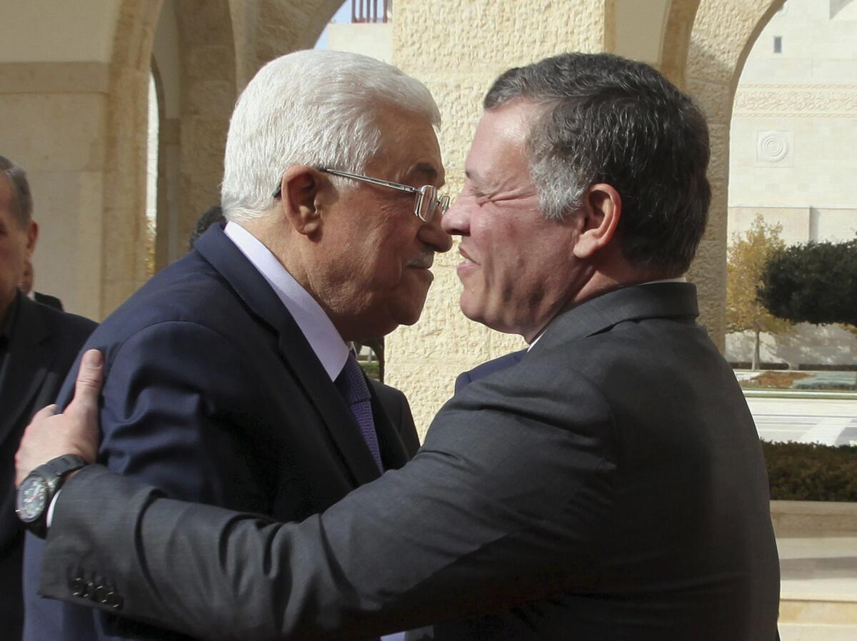 Jordan's King Abdullah II, right, welcomes Palestinian Authority President Mahmoud Abbas at the Royal Palace in Amman, Jordan.