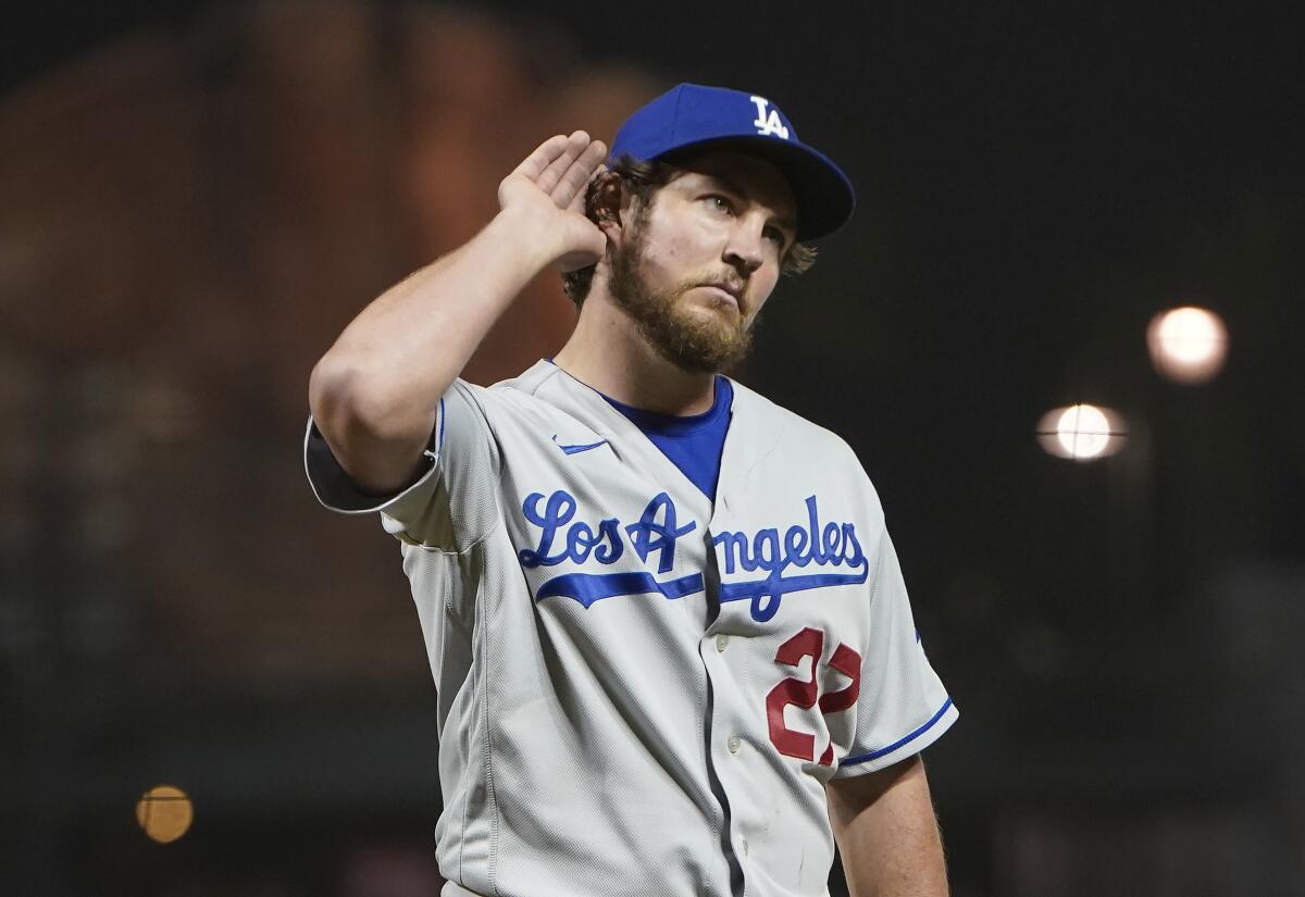 Trevor Bauer holds his right hand up to cup his ear.