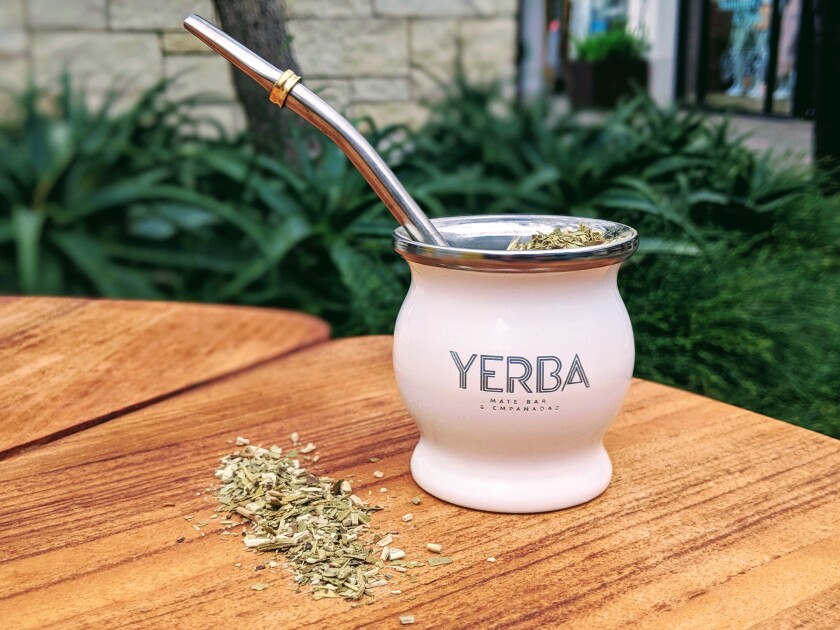 Yerba mate, a traditional South American drink that is a healthier alternative to coffee, is made from the dried leaves of an evergreen holly. It is served in a gourd-shaped cup with a special straw to filter the tea.
