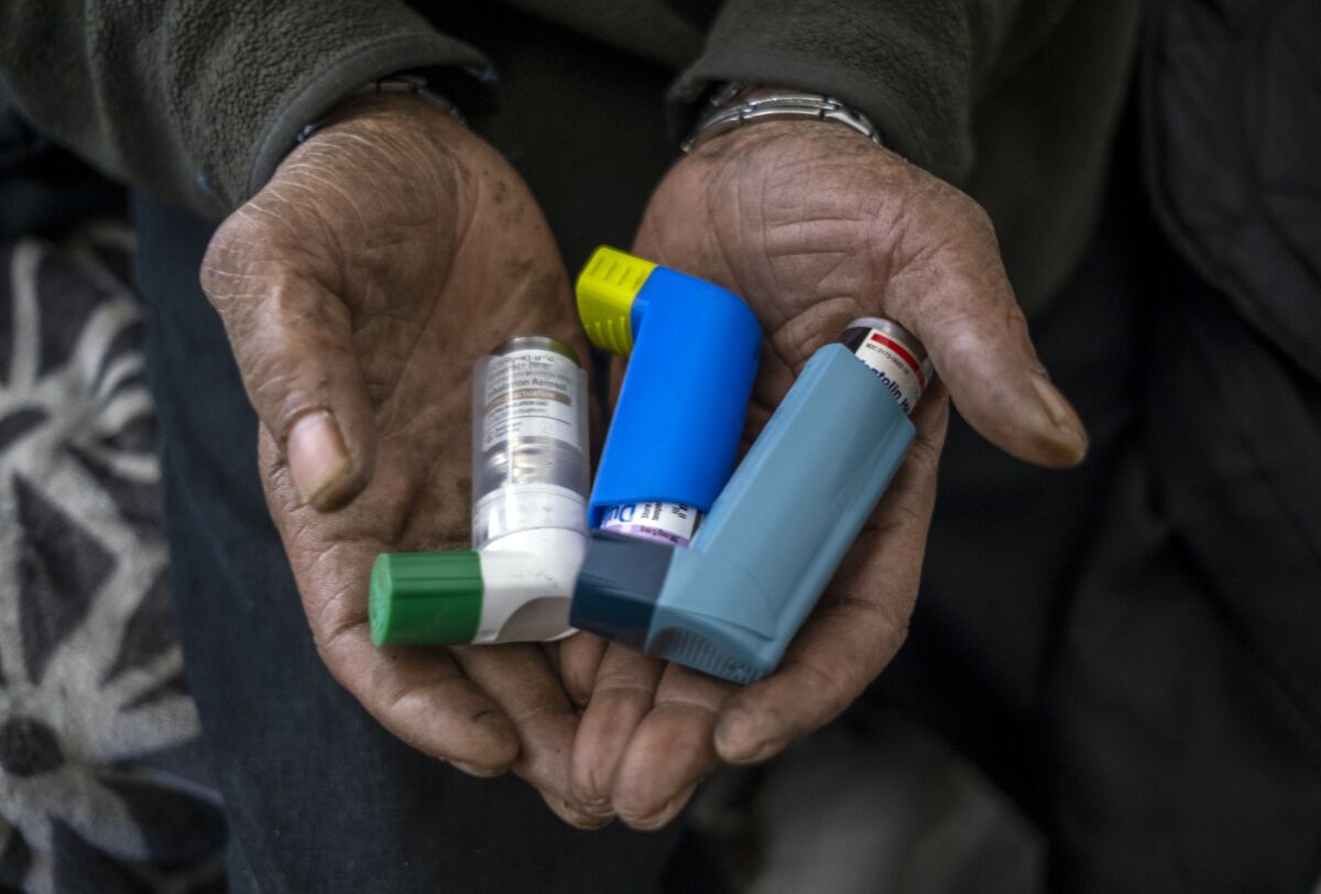 Edwin Linwood, 71, shows his inhalers in his room at the Madison