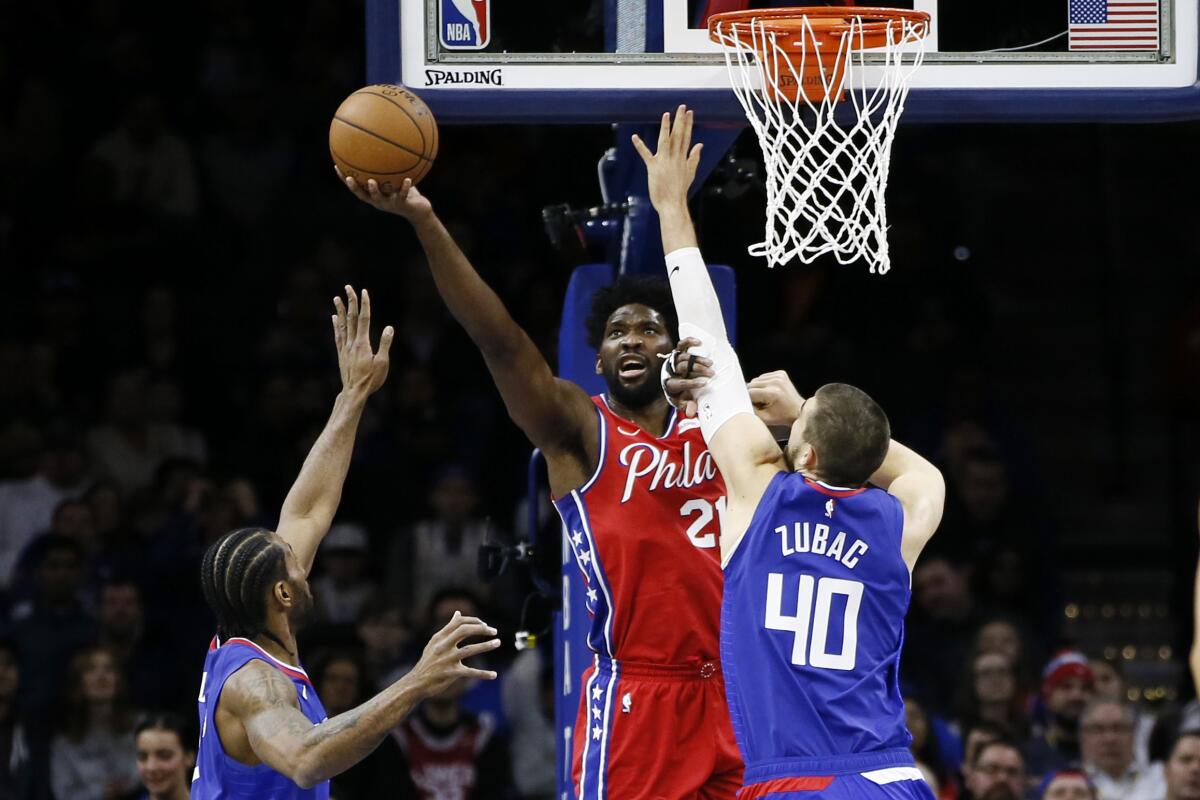 Clippers center Ivica Zubac and forward Kawhi Leonard try to prevent 76ers center Joel Embiid from scoring during a game Feb. 11, 2020, in Philadelphia.