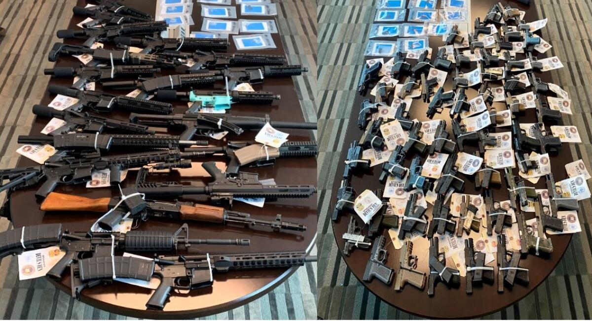 Rifles and pistols seized during an 18-month investigation into Escondido street gangs are displayed on tables in October.