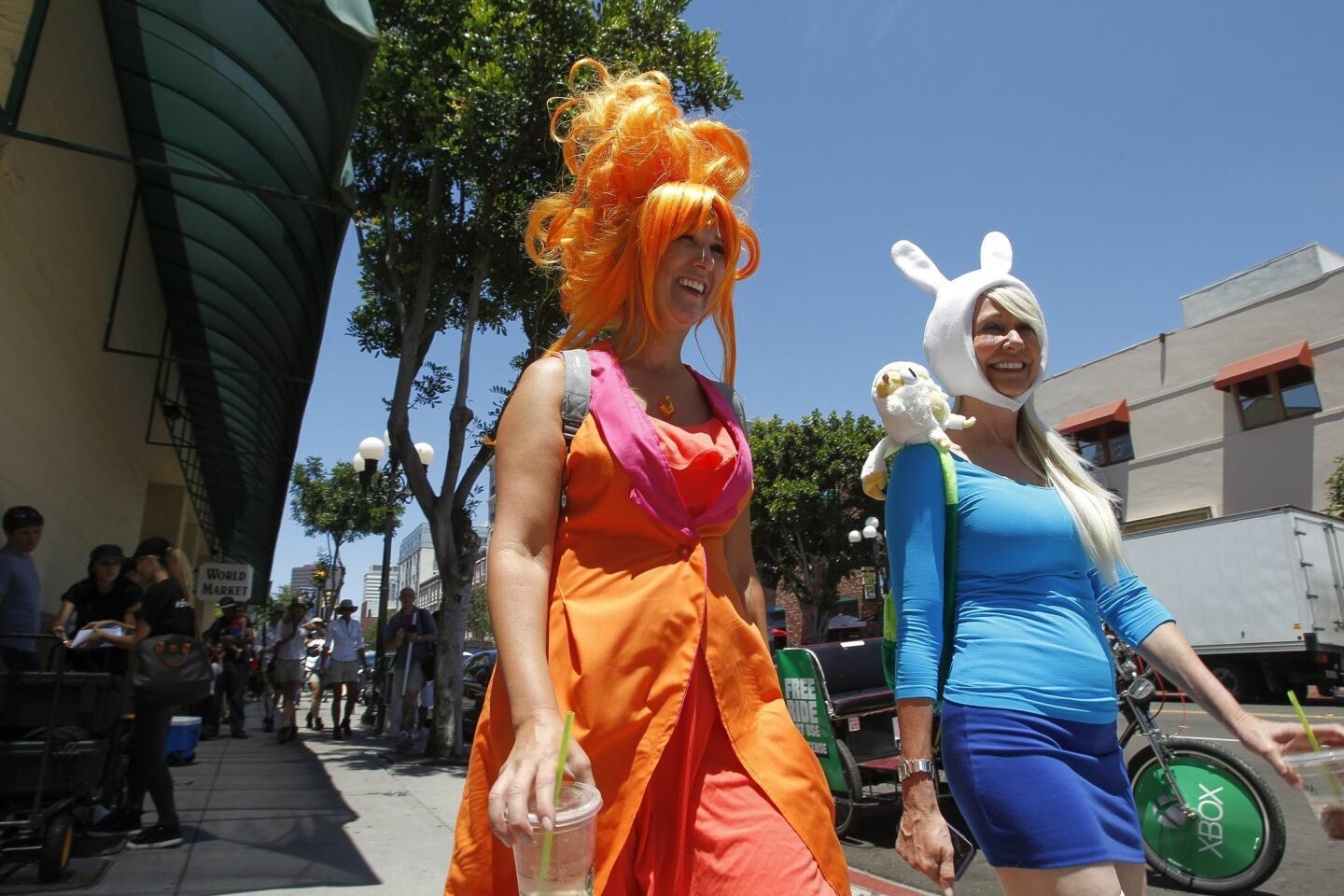 Paula Thomas, left, and Kat Bingaman are dressed as Fiona and the Flame Princess, characters from the Cartoon Network's Adventure Time, as they walk down Fourth Avenue.