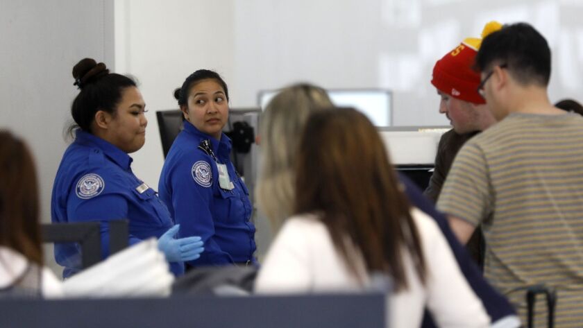 TSA agents check passengers at LAX in 2018. Last year, arrests for marijuana trafficking rose after California legalized the drug.
