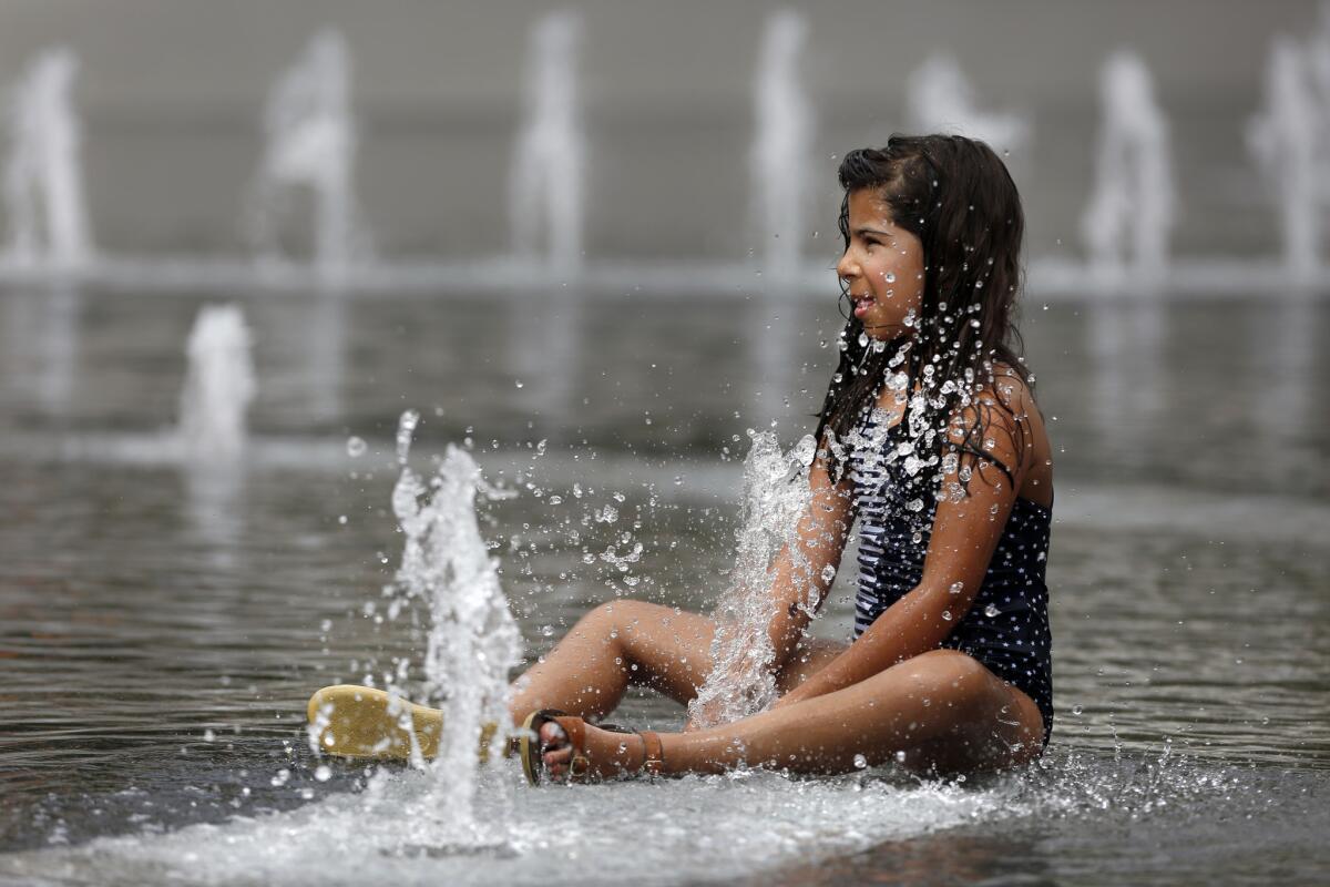 Nooria Retzer of Brooklyn, N.Y., cools off at the Grand Park Fountain on Sept. 9.