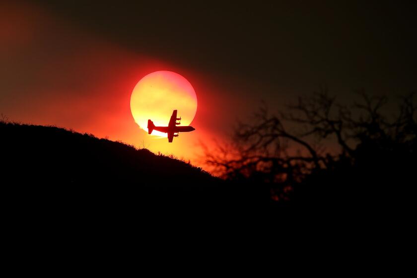 A firefighting air tanker flies in front of the setting sun while battling the Rocky fire in August near Clearlake, Calif. The U.S. Forest Service will see its firefighting budget rise in 2016.