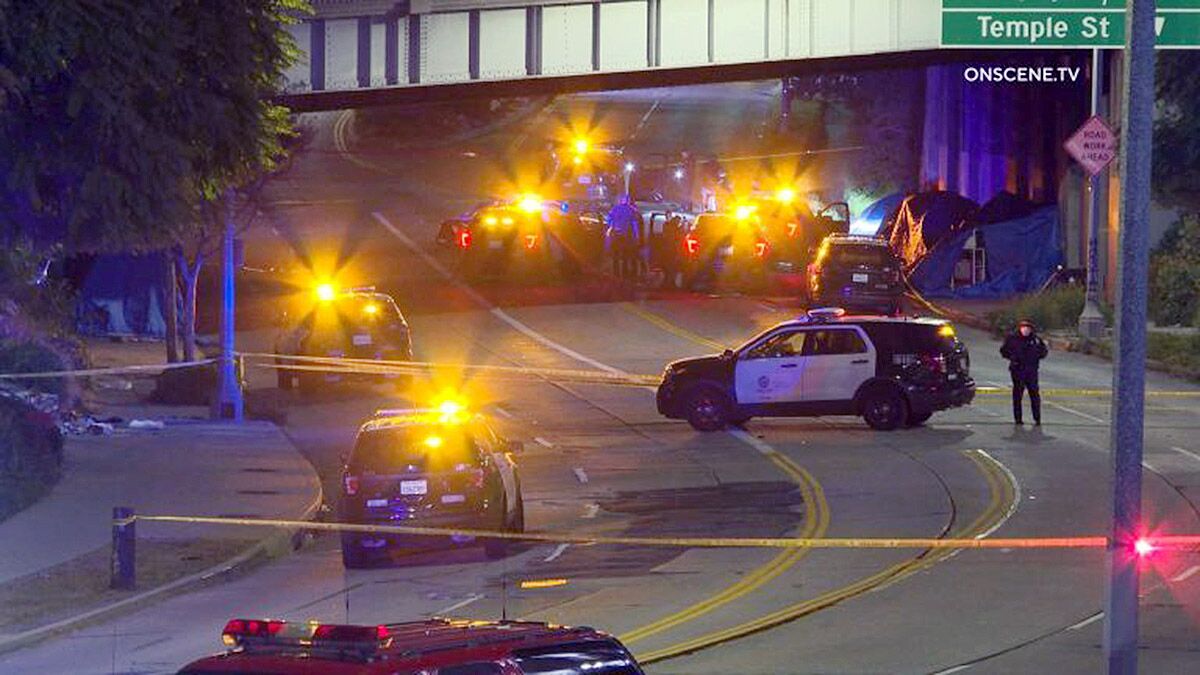 Emergency vehicles with lights flashing block a street at night