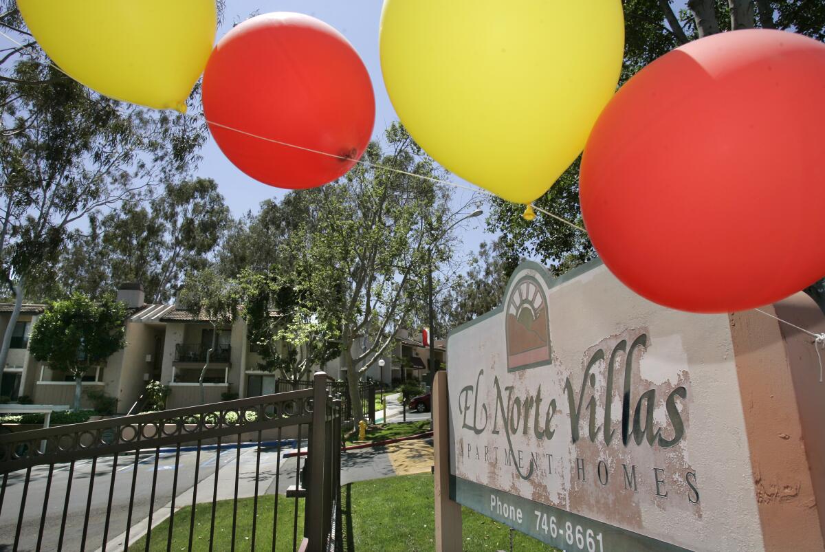 Helium balloons blow in the wind in front of the El Norte Villas apartment complex in Escondido.