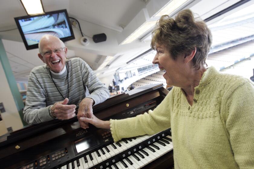 Dodgers organist Nancy Bea Hefley, right, shares a laugh with her husband, Billy, at Dodger Stadium before a game.