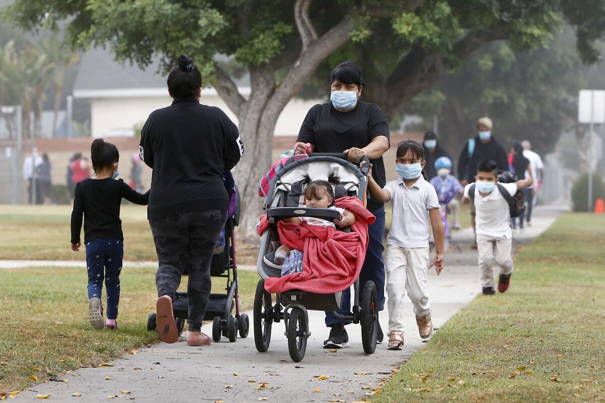 Parents walk their children to Rea Elementary School in Costa Mesa.