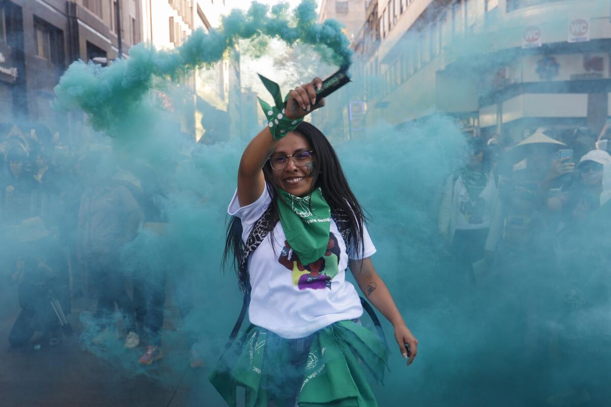 A woman sprays green smoke during an abortion-rights demonstration in Mexico City.