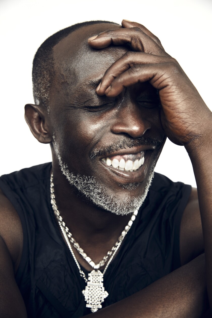 Actor Michael K. Williams smiles with his hand at his eyes.