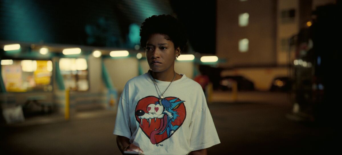 Keke Palmer stands in a parking lot at night in a scene from the movie "Nope."