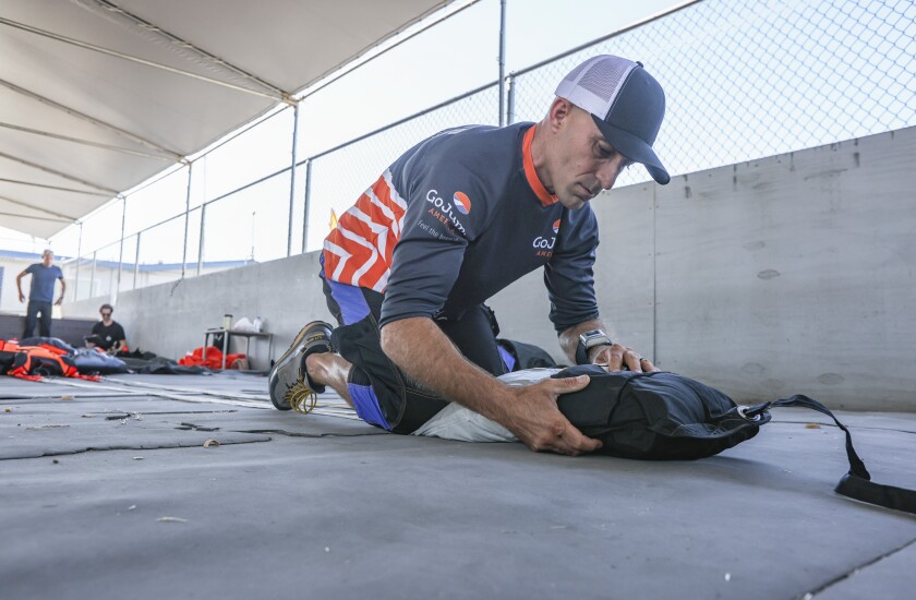 Ulotka wingsuit Chris Geller pakuje parasol przed założeniem końcówki skrzydła na GoJump Oceanside w czwartek.