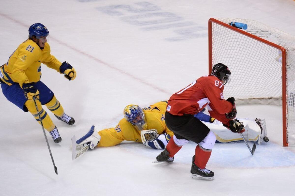 Canada's Sidney Crosby scores past Sweden goalie Henrik Lundqvist as Sweden's Loui Eriksson looks on.