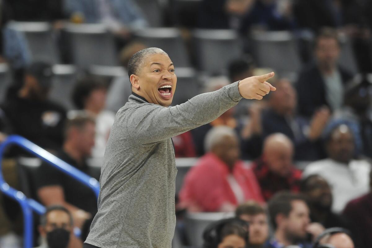 Clippers head coach Tyronn Lue yells instructions to his players on the court.