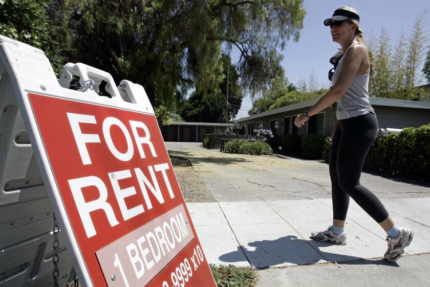 FILE - In this July 19, 2006 file photo, a woman walks next to a "For Rent" sign at an apartment complex in Palo Alto, Calif.