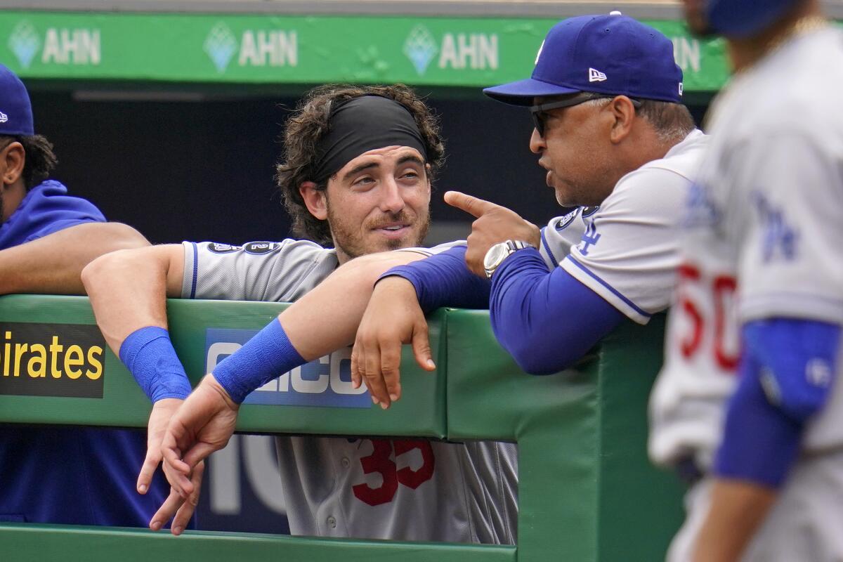 Dodgers manager Dave Roberts, right, talks with Cody Bellinger in the dugout on Thursday.