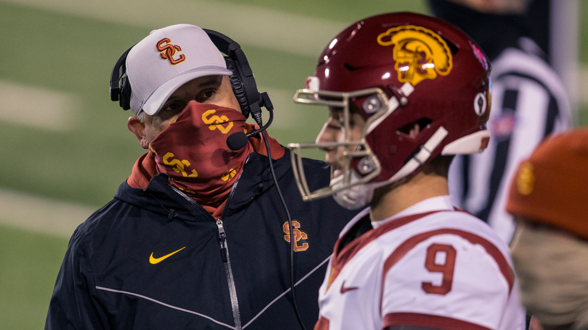 USC coach Clay Helton talks with quarterback Kedon Slovis on the sideline during a game