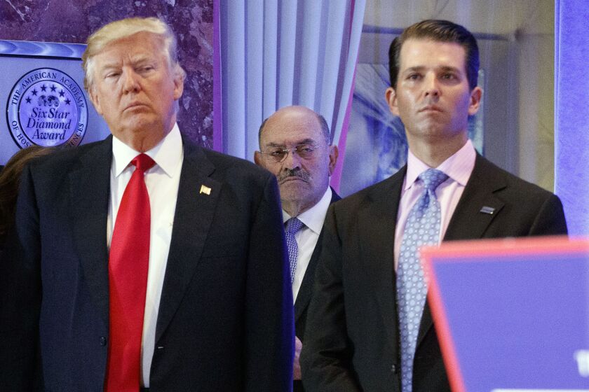 FILE - In this Jan. 11, 2017 file photo, Allen Weisselberg, center, is seen between President-elect Donald Trump, left, and Donald Trump Jr., at a news conference in the lobby of Trump Tower in New York. Donald Trump's former personal lawyer Michael Cohen mentioned Weisselberg, the Trump Organization chief financial officer, several times in his public House Oversight testimony, linking him to hush money payments to porn actress Stormy Daniels, who alleged she had an affair with Donald Trump. (AP Photo/Evan Vucci, File)