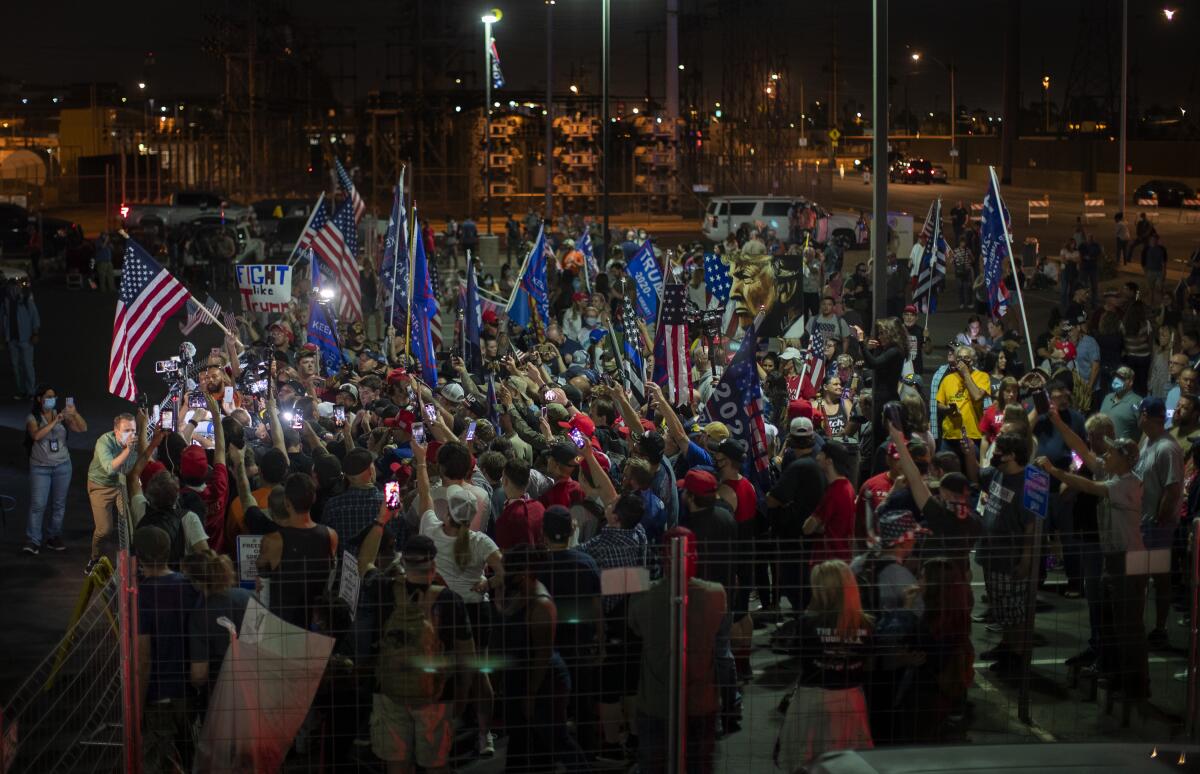 Trump backers around right-wing conspiracy theorist Alex Jones by the Maricopa County elections building Friday in Phoenix.