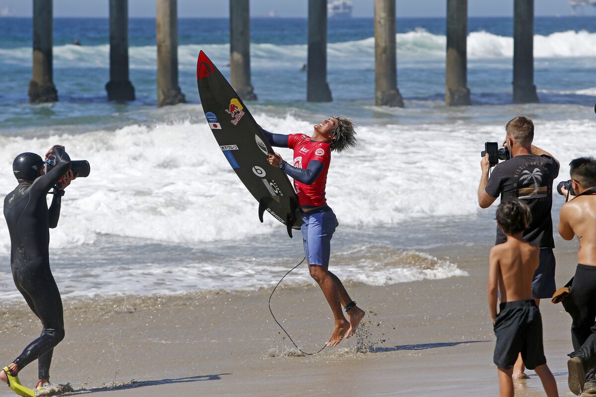 Huntington Beach's Kanoa Igarashi tosses his surfboard as he celebrates winning the ISA World Surfing Games men's title.