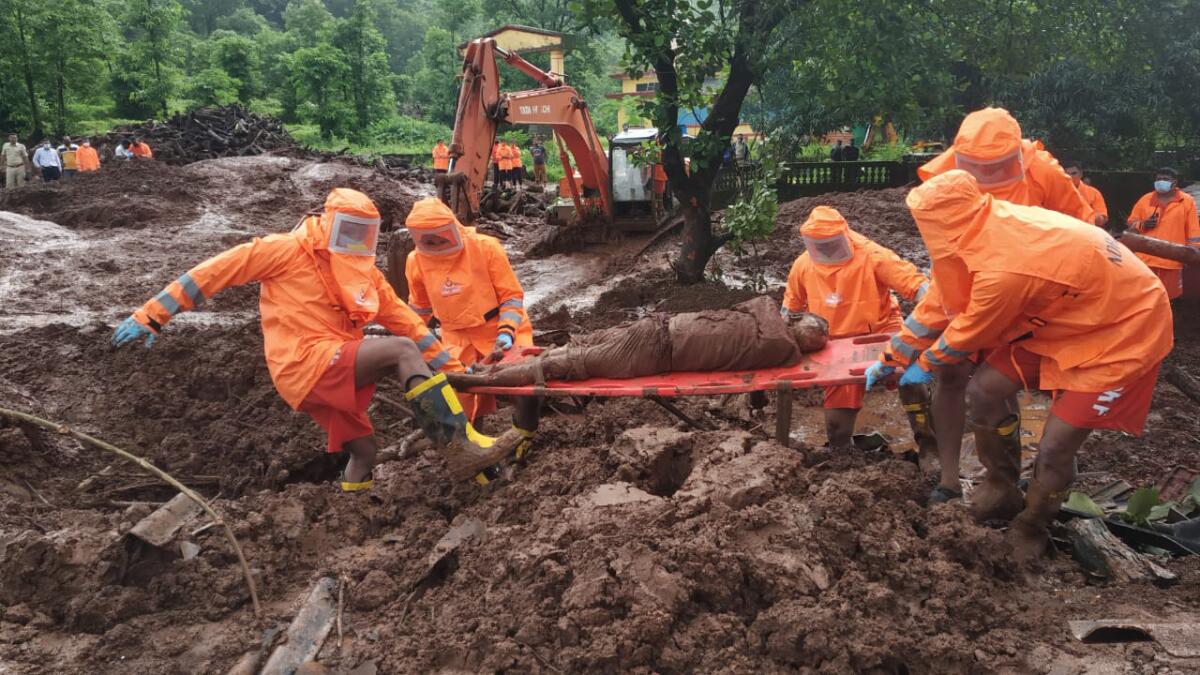  personal de emergencias recuperando el cuerpo de una víctima de un alud de tierra en Ratnagiri,
