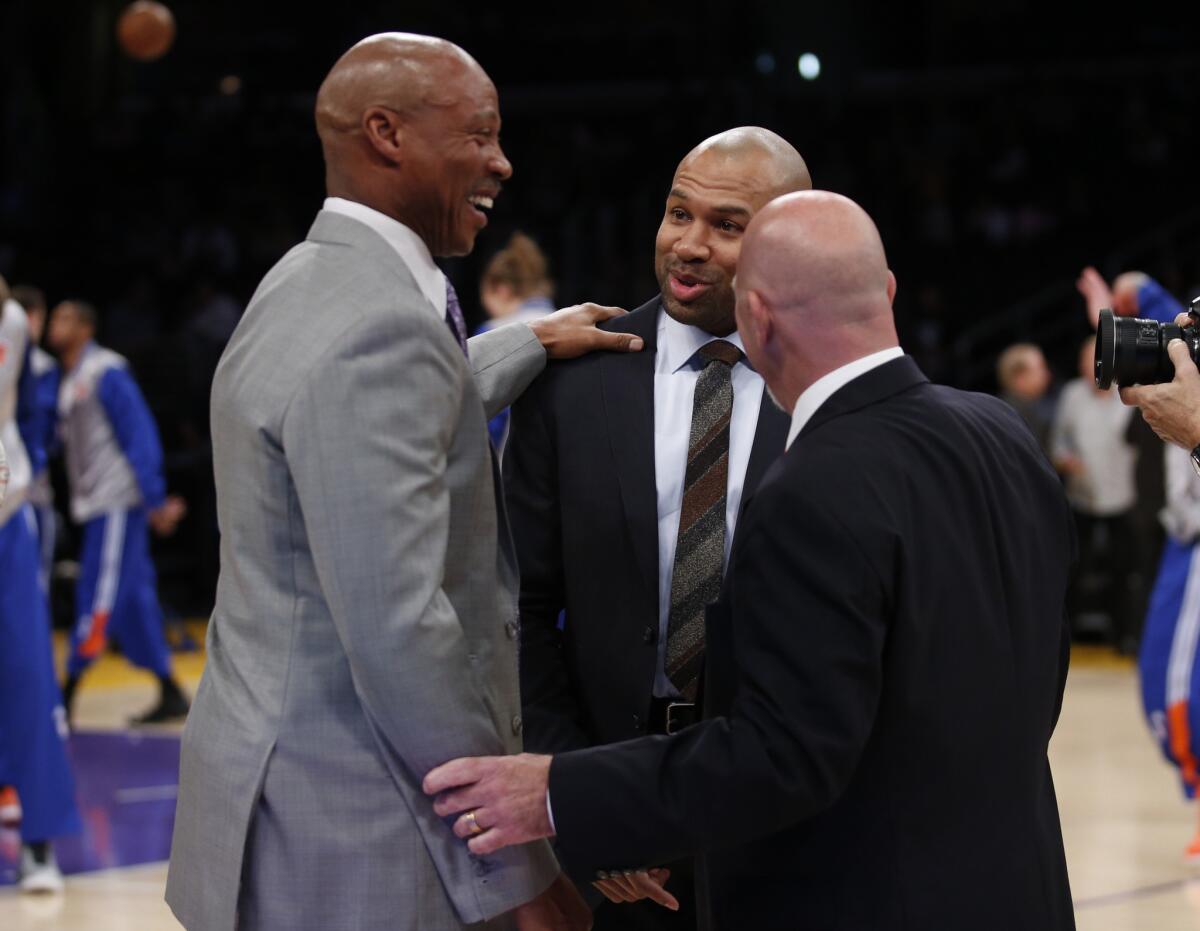 Knicks Coach Derek Fisher, center, a former Lakers player, smiles during a chat with Lakers Coach Byron Scott, left, and trainer Gary Vitti, right, before the Knicks and Lakers squared off.