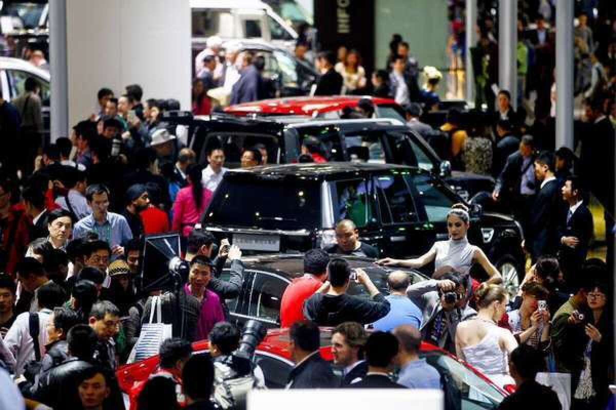 Visitors jam vehicle displays at the Auto China Show 2012 in Beijing. China auto sales jumped 13% in April as U.S. automakers tried to build market share.