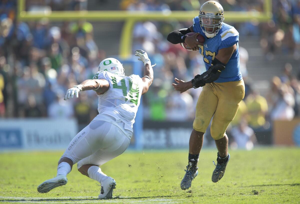 UCLA quarterback Brett Hundley evades Oregon linebacker Rodney Hardrick late in the second half.
