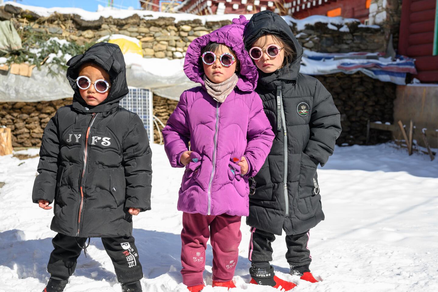 Children in a Tibetan family, wearing sunglasses outdoors, on Jan. 24, 2020.