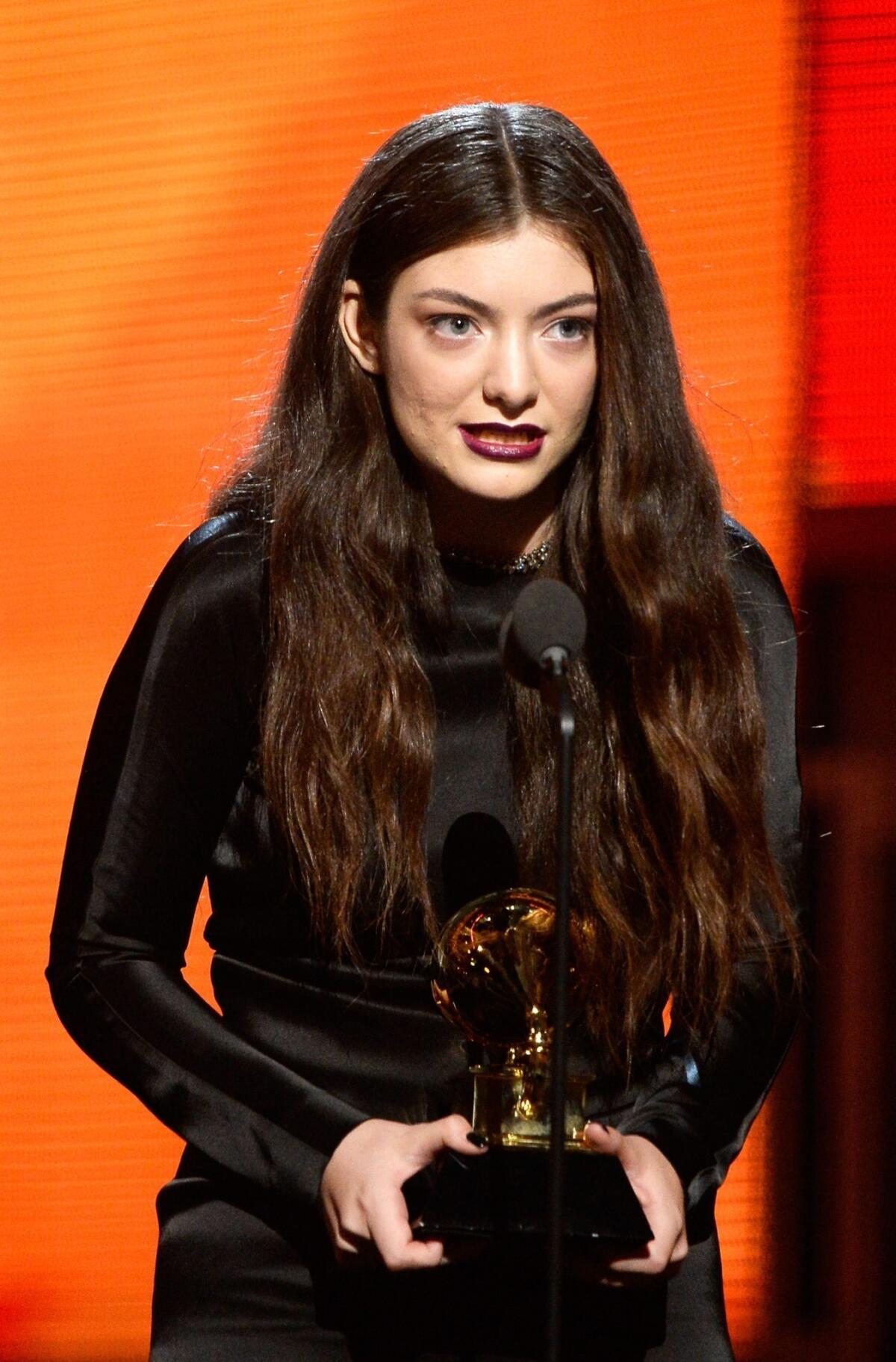 Lorde's deep purple makeup is a modern look with a focus on the lips.