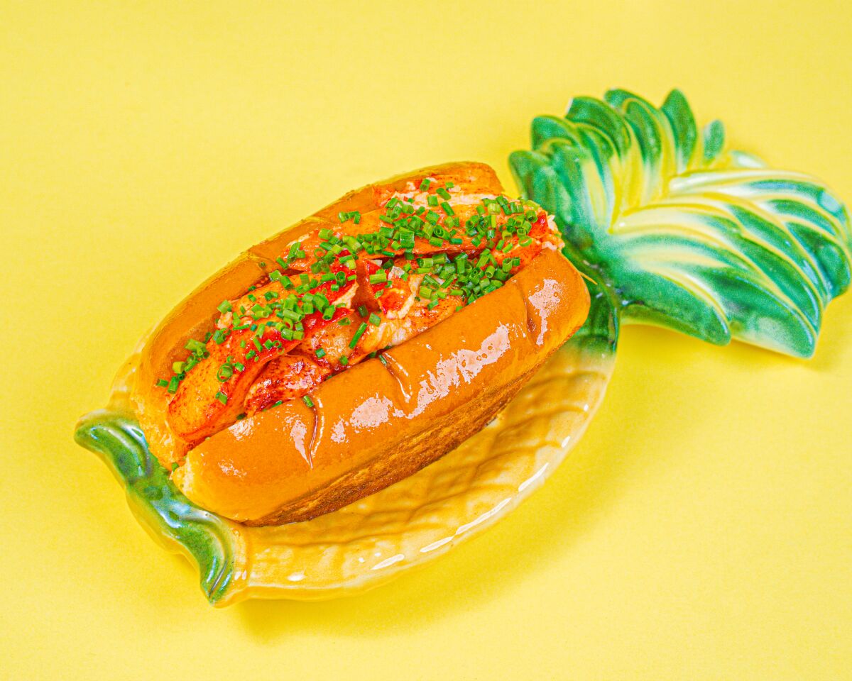 A vibrant photo of a lobster roll on a pineapple-shaped plate,  shot on a bright yellow backdrop.